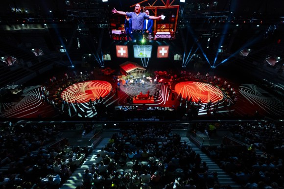Blick von oben in eine Eventhalle mit Bühne und Beleuchtung