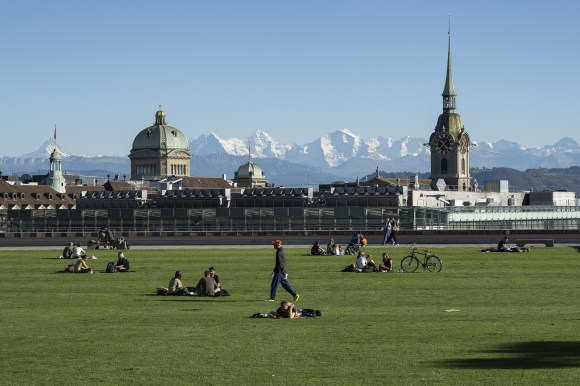 Blick von der Grossen Schanze in Bern auf Bundeshaus, eine Kirche und dahinter die Berge