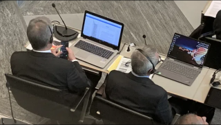 Duas pessoas sentadas frente a computadores