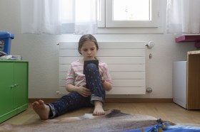 young girl reading by radiator