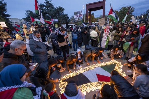 Pro-Palestine demonstrators in Geneva light candles on the ground